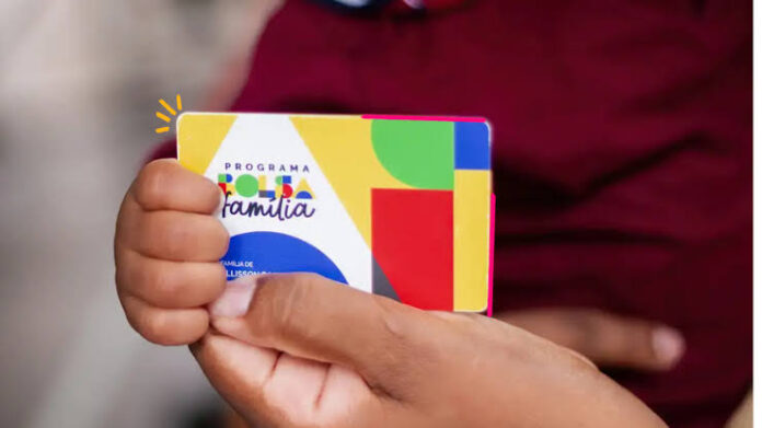 Criança segura cartão do Programa Bolsa Família